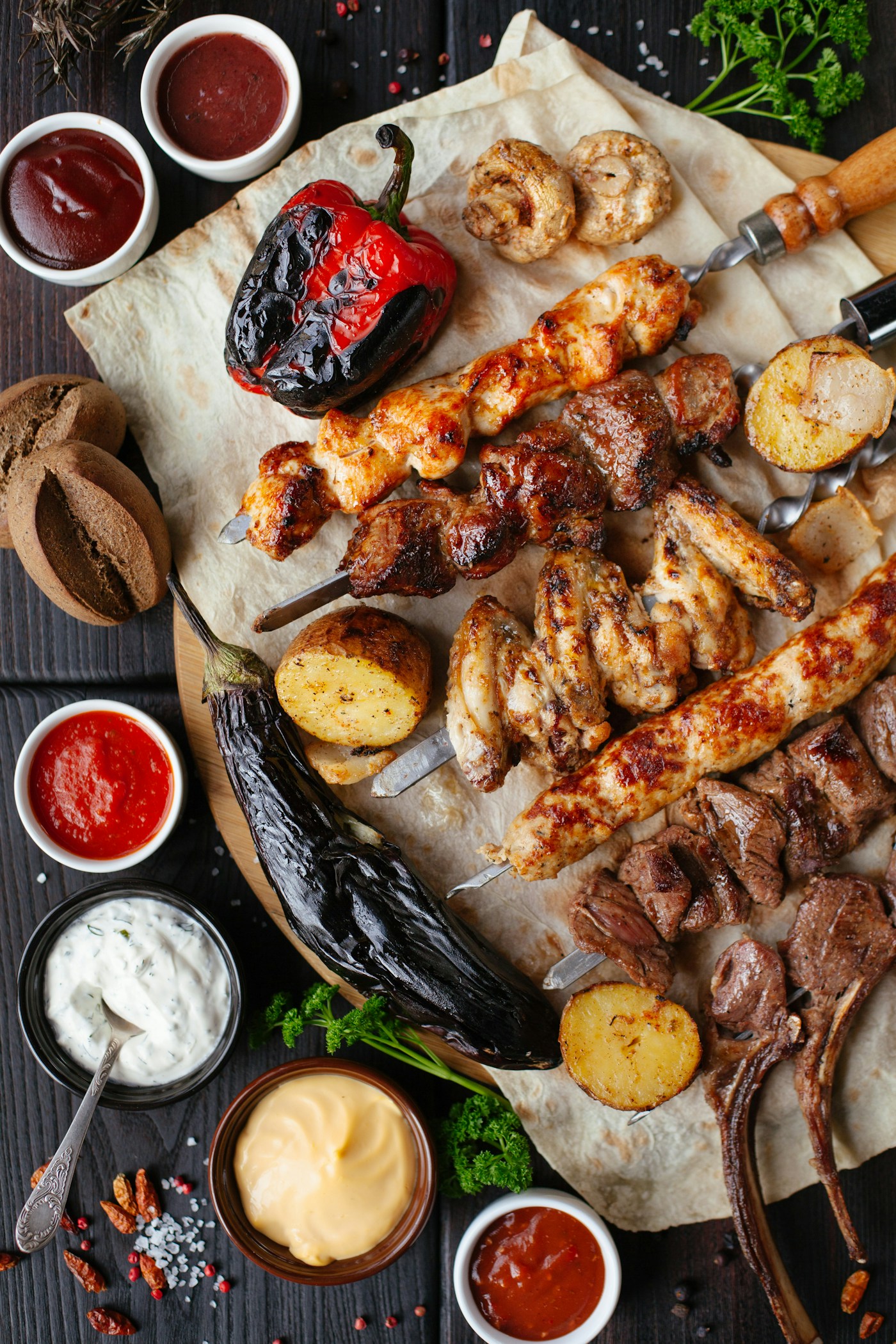 Grillplatte mit mediterranen Fleischspießen, Paprika und Dips.