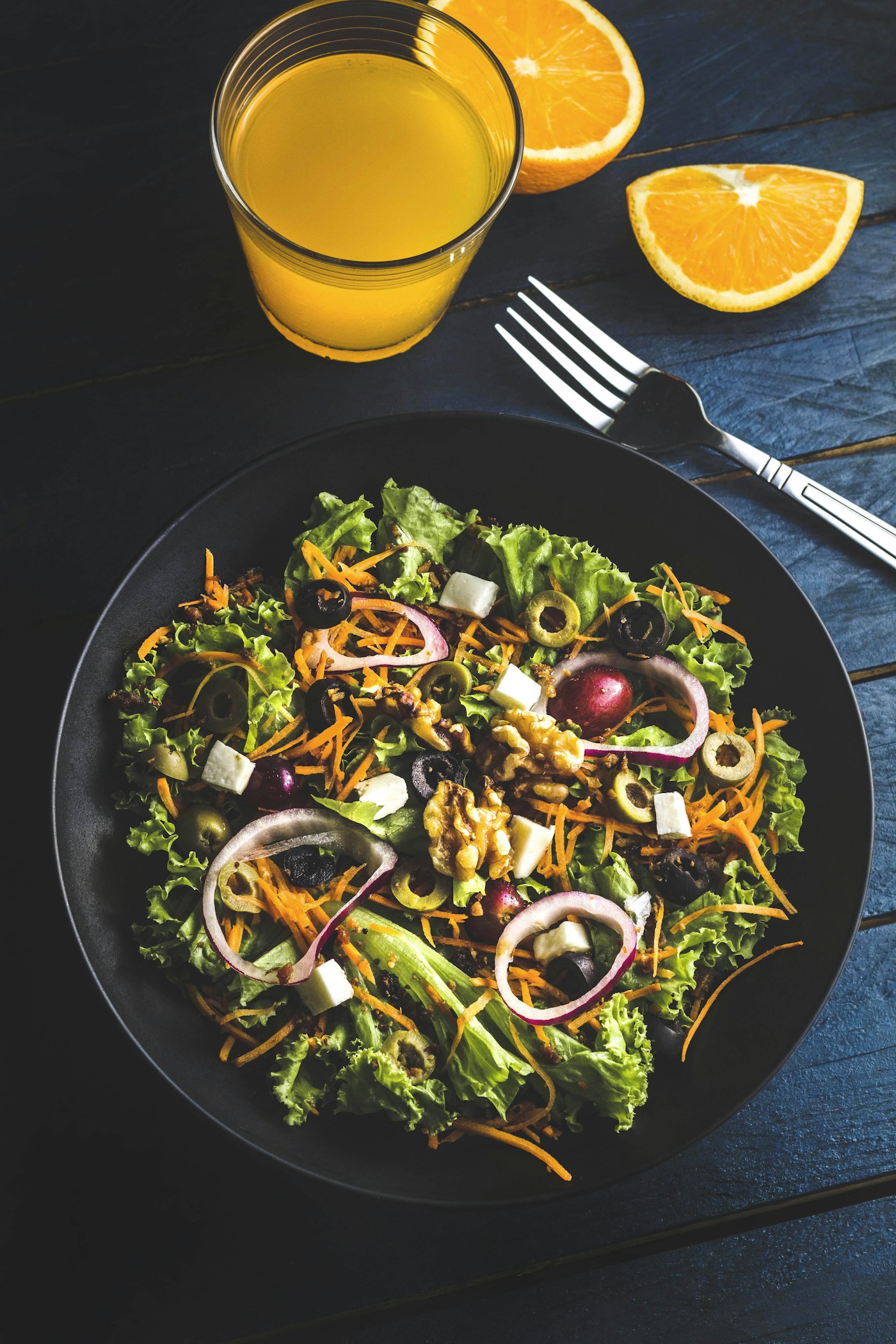 Frischer mediterraner Salat mit Oliven, Zwiebeln, Feta und Nüssen.